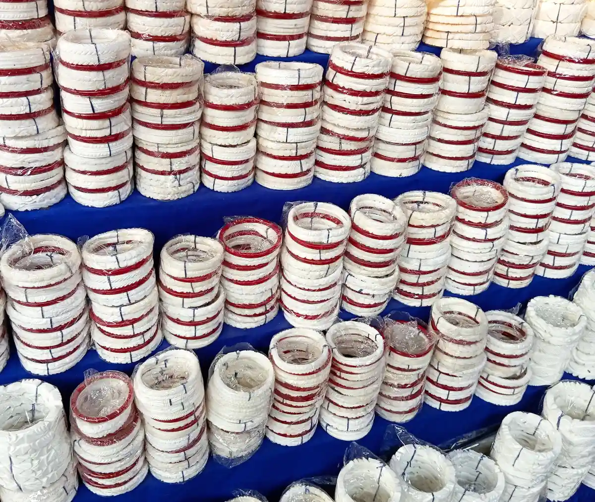 Stacks of white shankha conch-shell bangles with red stripes, the Bengali married woman's bangle, laid out for sale